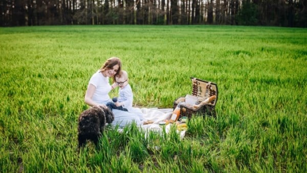 Family picnic with dog in field